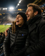 Paar im Fußballstadion, sie trägt die beheizbare ArticLux Steppjacke