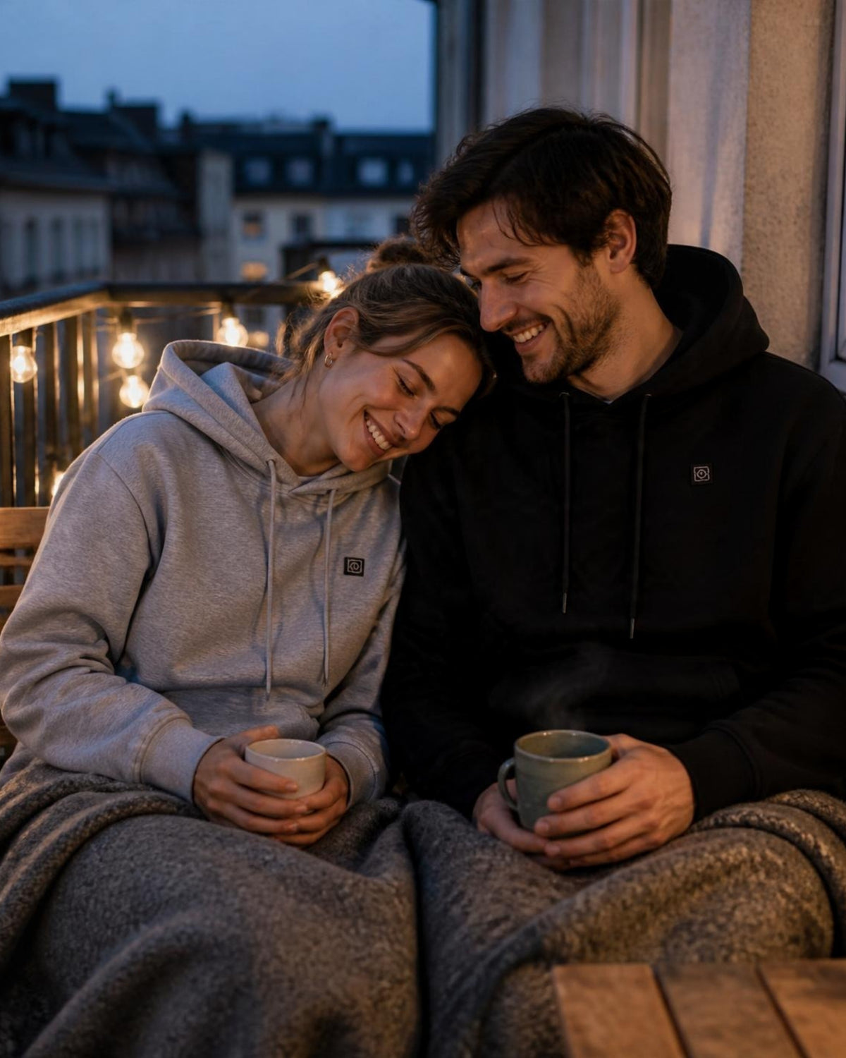 Paar in grauem und schwarzem ArticLux Wärmenden Hoodie auf dem Balkon