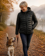 Frau mit Beagle am See in der beheizbaren ArticLux Steppjacke